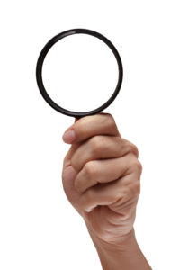 Magnifying glass in hand isolated on white background